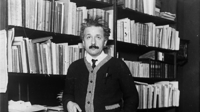 Albert Einstein standing by bookshelf