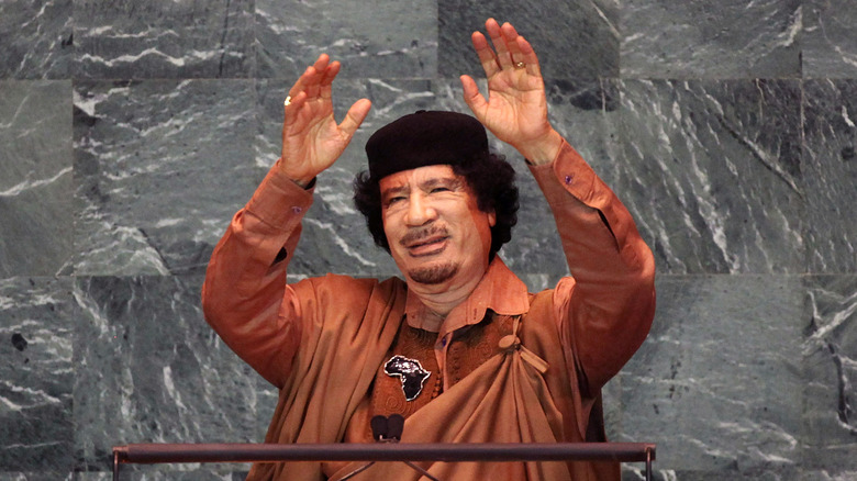 Muammar Gaddafi with hands upraised