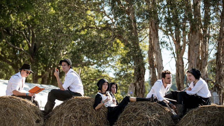 Amish sitting on bales of hay