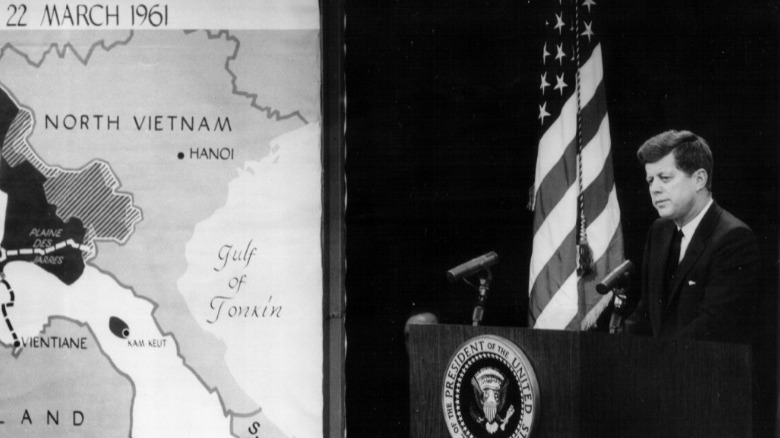 John F. Kennedy at podium next to map of Vietnam