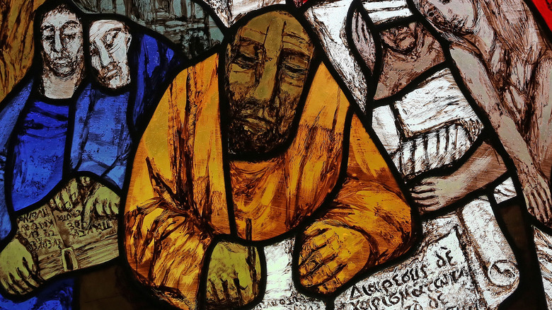 Stained glass image of Paul writing