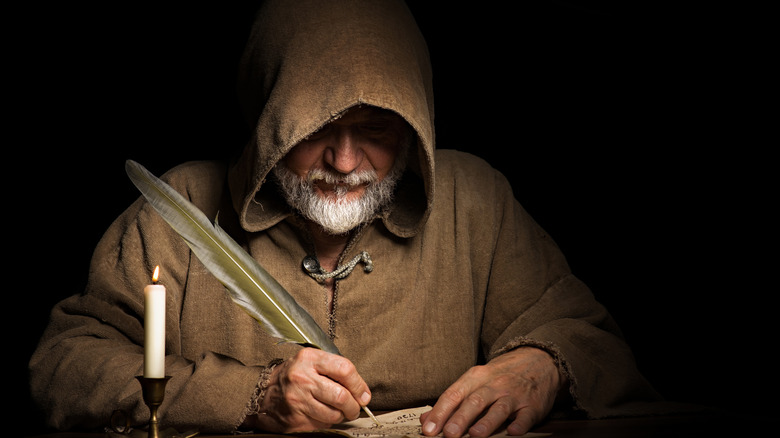 Man in a cloak writing