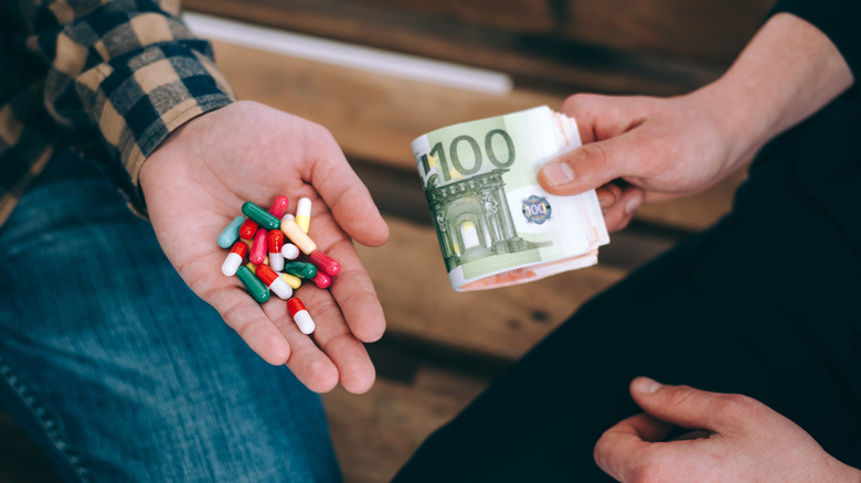 Pills being purchased on a bench