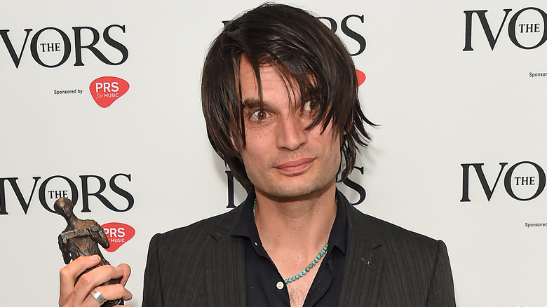 Jonny Greenwood of Radiohead holding award with wild eyes