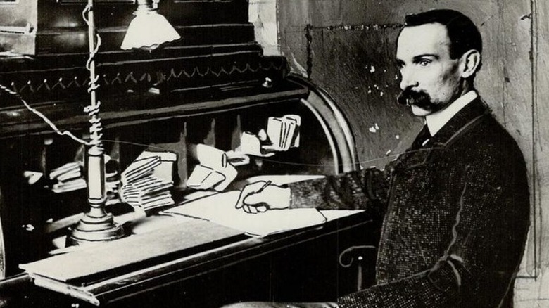 Ambrose Small writing at a desk