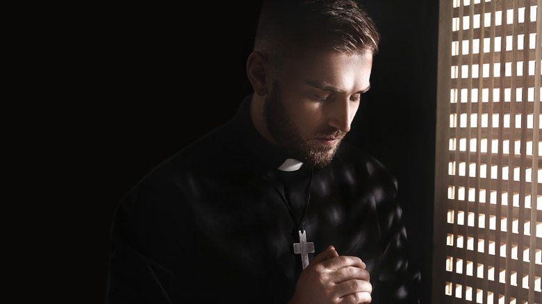 Priest in confessional booth