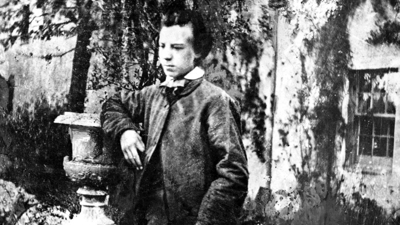 Young Alexander Graham Bell leaning on post 1861
