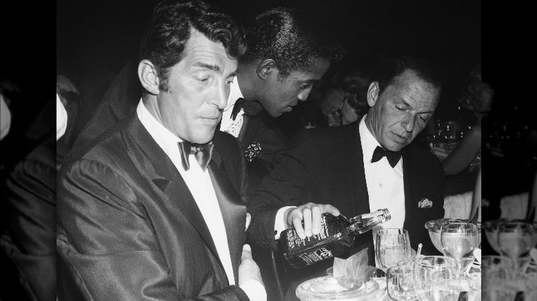 Sammy Davis Jr. pouring drinks for Frank Sinatra and Dean Martin