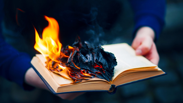 Book on fire in hands