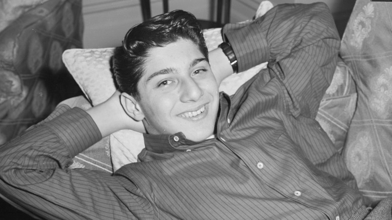 Young Paul Anka reclining smiling