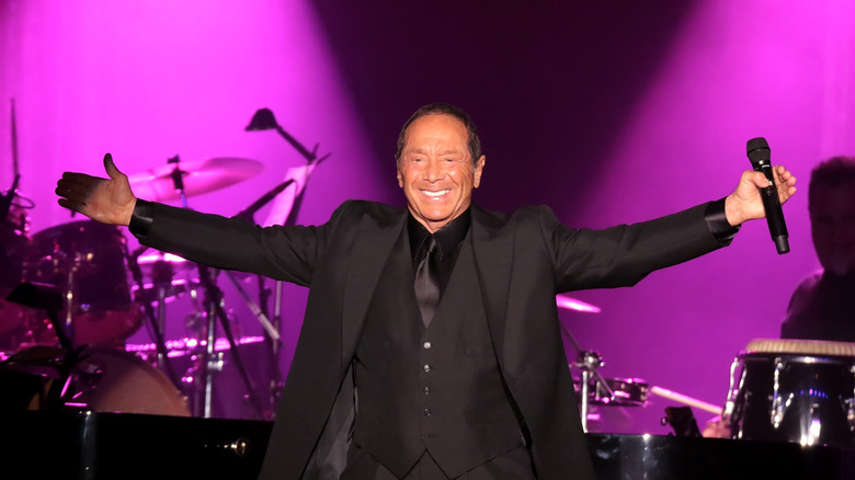Paul Anka arms spread smiling on stage