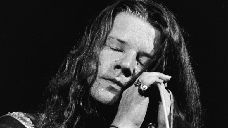 janis joplin resting on microphone