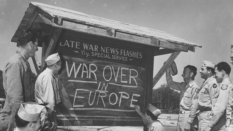 U.S. servicemen announcing end of WWII in Europe