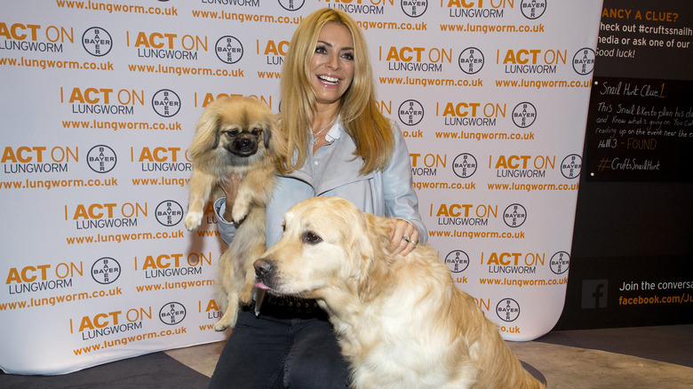 Tess Daly posing at a charity event with two dogs