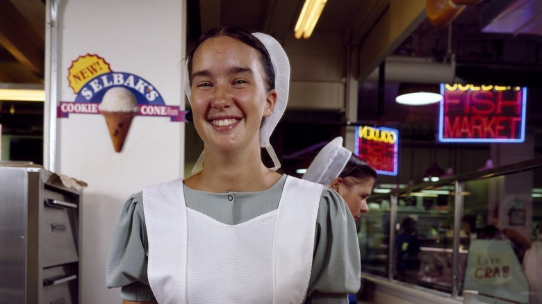 A young Amish woman from Lancaster County serves fresh-cooked soft pretzels at the Reading Terminal Market in Philadelphia, Pennsylvania