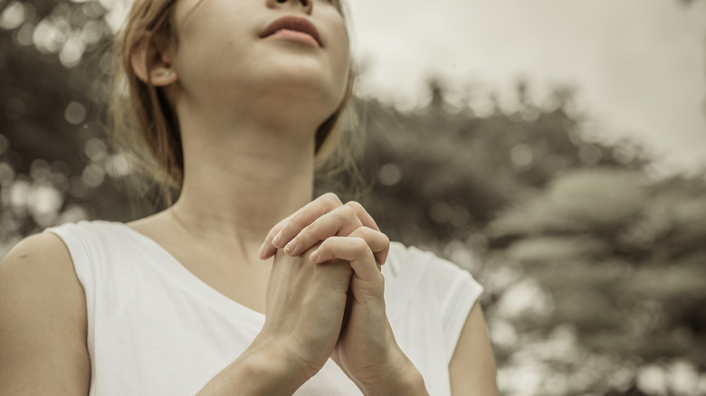 Woman in white top praying