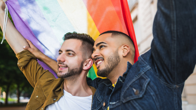Gay couple holding rainbow flag