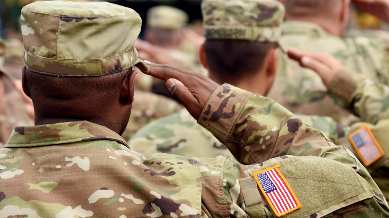 Uniformed American soldiers saluting